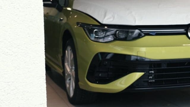 Frontpartie eines gelben Sportkompaktwagens mit teilweiser Abdeckung, Automotive-Detailaufnahme
